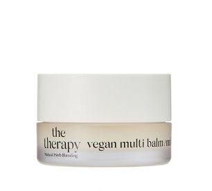 Small jar of smooth vegan multi balm with moisturizing formula in frosted glass container and white lid on white background