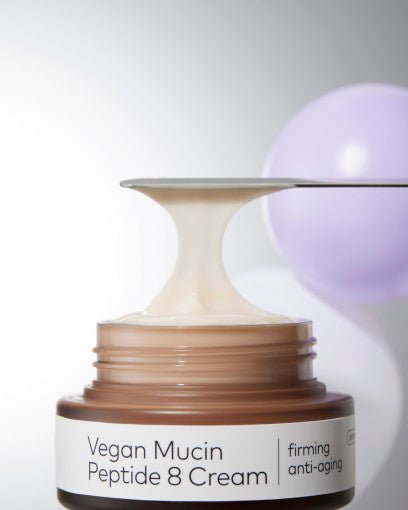 Open jar of creamy beige firming anti-wrinkle peptide cream with smooth texture stretched on spatula above jar