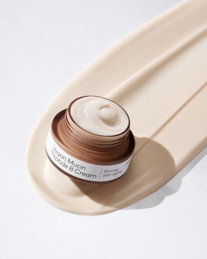 Open jar of creamy firming peptide 8 anti-wrinkle cream on smooth beige swatch background