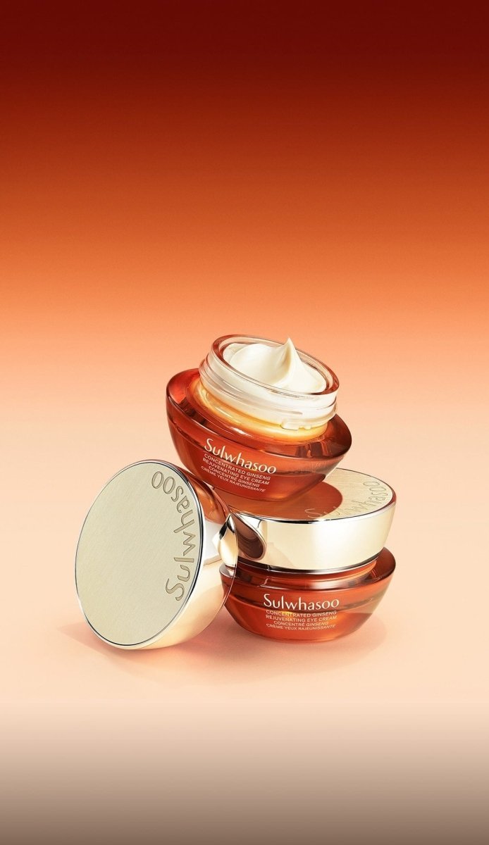 Two amber glass jars of nourishing eye cream with smooth texture swirled on top against warm gradient background