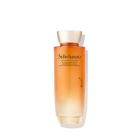 Tall gradient amber glass bottle of rejuvenating ginseng water with elegant gold cap on white background