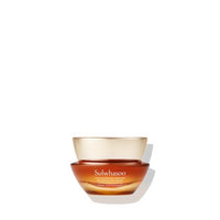 Amber glass jar of renewing cream with gold lid reflecting hydration benefits on white background