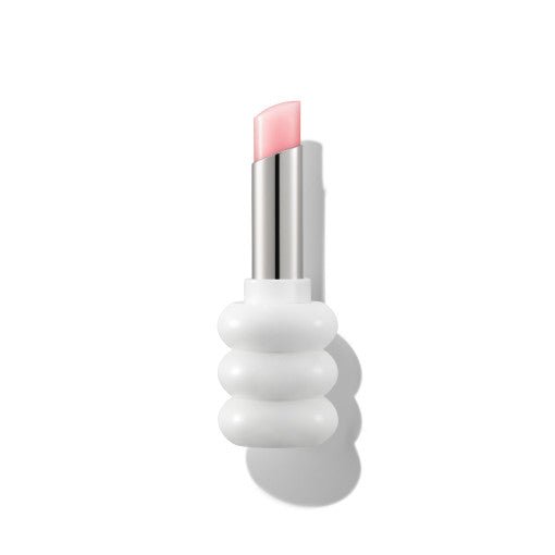 Soft pink tinted lip balm with glossy finish in a modern white sculpted tube packaging on white background
