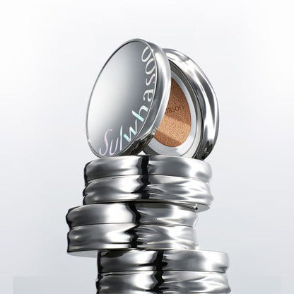 Stack of shiny silver compact cushions with reflective lids and visible beige cushion inside the top one