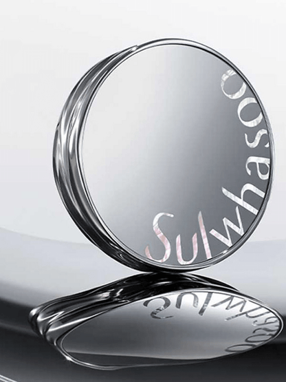 Sleek reflective compact case with subtle curved edges and partial brand name on silver surface on light background