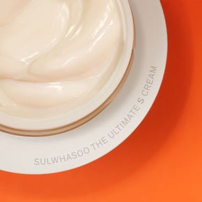 Open jar of smooth, creamy moisturizer with visible soft texture on a warm orange background