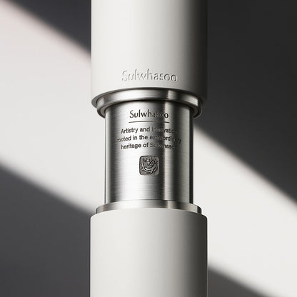 Close-up of sleek matte white and brushed metal serum bottle segment with engraved brand name and heritage text detail