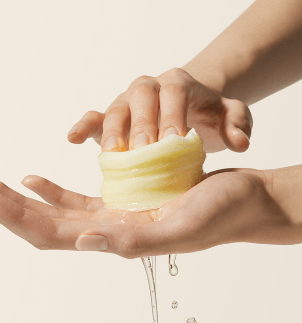 medicube Deep Vita C Pad 150g (70 Pads) showing hands squeezing translucent cotton pad with brightening essence dripping