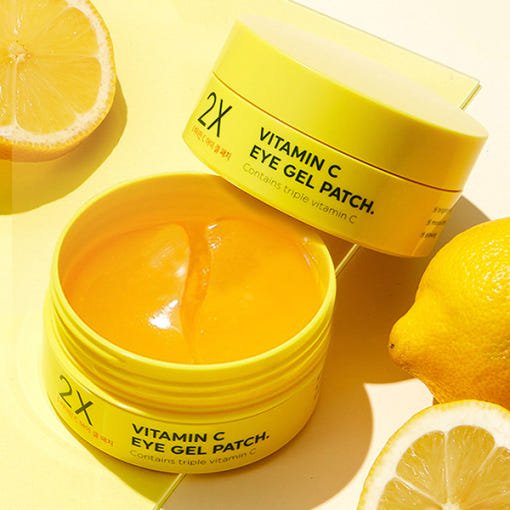 Bright yellow jar of vitamin C eye gel patches surrounded by fresh lemon halves highlighting moisturizing care benefits