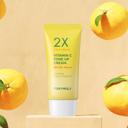 Yellow tube of vitamin C tone up cream with SPF50+ protection surrounded by fresh yellow citrus fruits