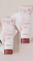 Two soft pink tubes of Cherry Blossom body cream with floral accents and deep hydration benefits on light background