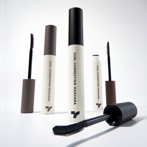 Set of beige and black curl correcting mascaras with curved applicator brushes highlighting clump-free formula benefits