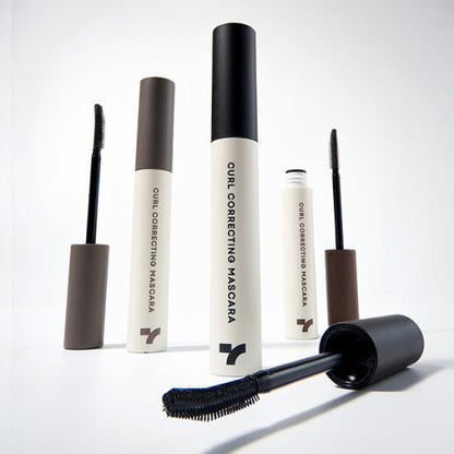 Set of beige and black curl correcting mascaras with curved applicator brushes highlighting clump-free formula benefits