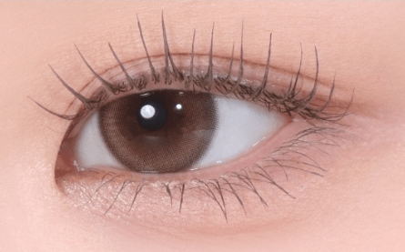 Close-up of a brown eye with naturally curled and separated lashes showcasing clump-free mascara effect
