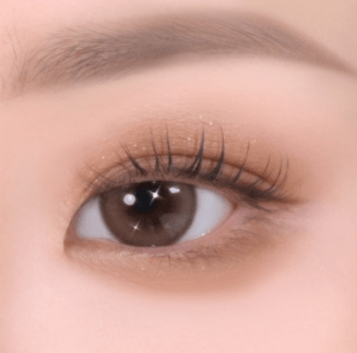 Close-up of a soft-textured eye shadow application on eyelid enhancing the natural brown eye color with subtle shimmer.
