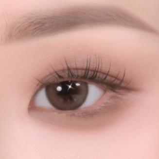 Close-up of an eye with natural-toned eyeshadow and soft, well-defined eyelashes enhancing a smooth eyelid texture