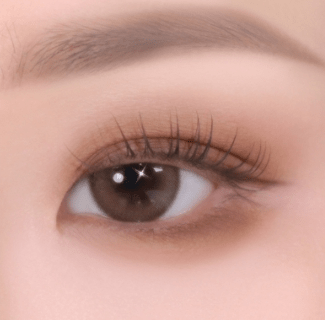 Close-up of an eye with soft textured brown eyeshadow enhancing natural depth and subtle definition.