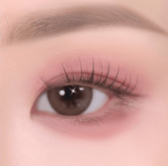 Close-up of a brown eye with soft pink eyeshadow and natural-looking curled eyelashes highlighting gentle texture