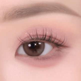 Close-up of an eye with soft pink eyeshadow and natural-looking lashes showcasing smooth, delicate texture application