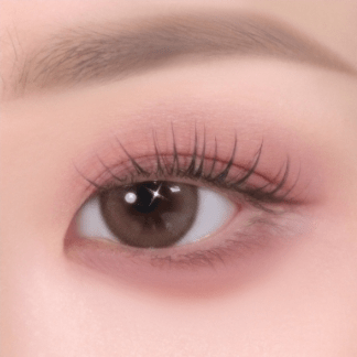Close-up of eye with soft pink eyeshadow and natural, fluttery lashes highlighting delicate texture and smooth finish