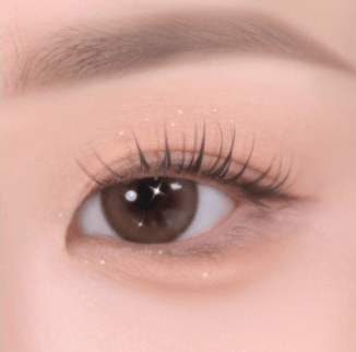 Close-up of an eye with softly textured eyeshadow in natural tones enhancing delicate lashes and smooth skin around it
