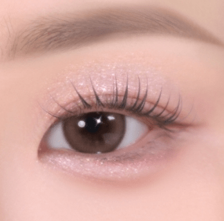 Close-up of eye with soft-textured shimmery light pink eyeshadow enhancing natural lash line and skin tone