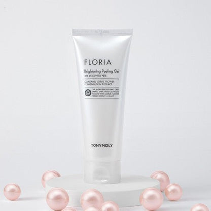 White tube of gentle brightening peeling gel elevated on round platform surrounded by soft pink pearl-like spheres