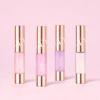 Four slim tubes of lip tint with shimmering finishes in soft pink, bright pink, lilac, and clear shades against pink backdrop
