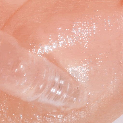 Close-up of clear tinted gel with glossy texture applied on skin for instant plumping effect