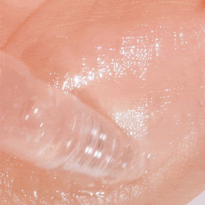 Close-up of clear tinted gel with glossy texture applied on skin for instant plumping effect