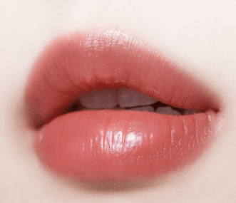 Close-up of lips with glossy coral tint showcasing smooth, hydrated texture and natural moisture retention benefits