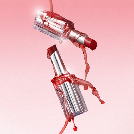 Red tinted lip balm with clear glossy casing and syrup-like liquid dripping against pink background