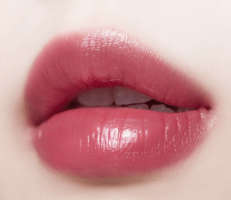 Close-up of lips with glossy soft pink tint showing hydrated, natural moisture-retaining lip color effect