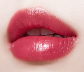 Close-up of lips wearing glossy, hydrated tint with vibrant red color showing smooth moisture-retaining finish