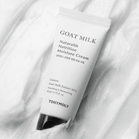White tube of moisturizing cream with black cap, featuring goat milk extract and hydration benefits on smooth white background