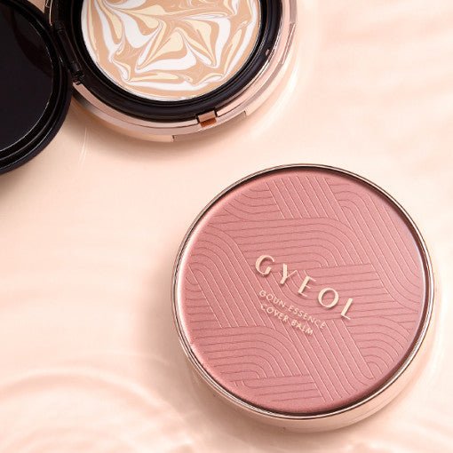 Compact cushion foundation with swirling beige and white tone and pink embossed cover labeled for high-coverage balm