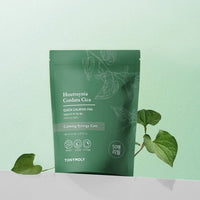 Green resealable pouch of calming skincare pads with botanical leaf illustrations on light background