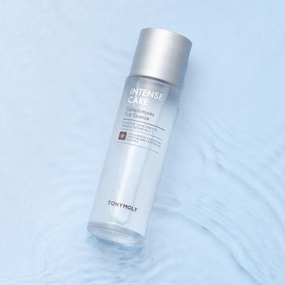 Clear skincare essence bottle with silver cap on rippled light blue surface highlighting enhanced elasticity benefits