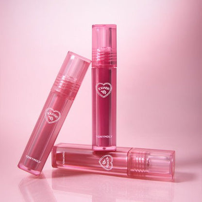 Three pink translucent lip gloss tubes arranged on pink background showcasing long-lasting color benefit