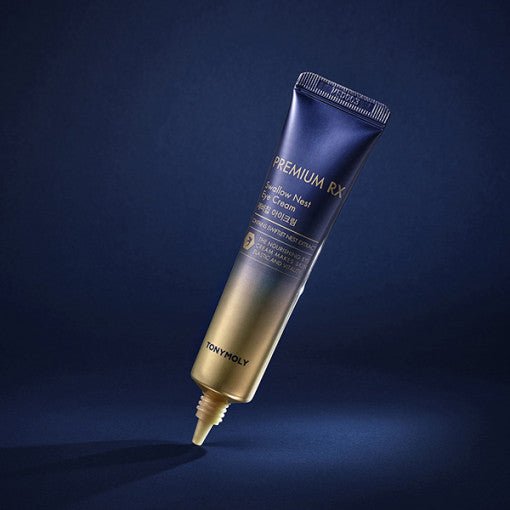 Gradient tube of skin-brightening eye cream with sleek gold and deep blue packaging on dark blue background