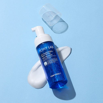 Blue foam cleanser bottle with white pump resting on smooth white foam on a light blue background
