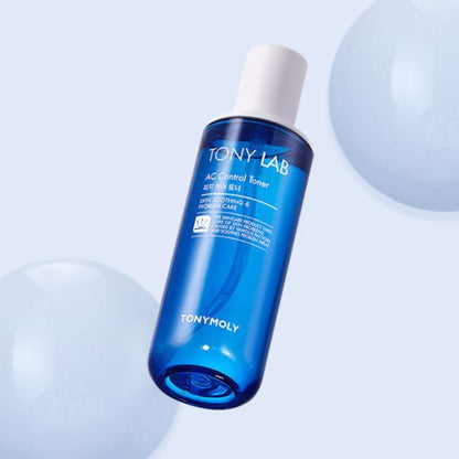 Blue translucent bottle of AC Control Toner with white cap shown against pale background with soft spheres nearby