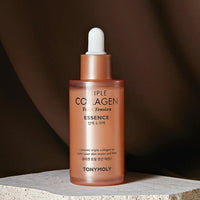 Frosted rose gold serum bottle with white dropper atop textured stone against dark soft backdrop