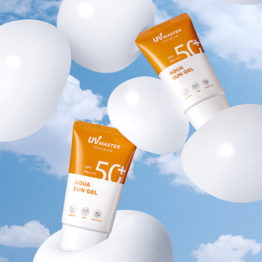Two orange and white sun gel tubes floating among white balloons against a bright blue sky with clouds