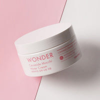 White jar of ceramide water cream with pink text placed on a pink and white split background for deep hydration skincare