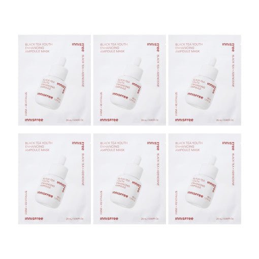 Six white sachets of black tea ampoule masks with rose gold text and dropper bottle image on each pack against a white background