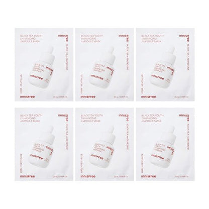 Six white sachets of black tea ampoule masks with rose gold text and dropper bottle image on each pack against a white background