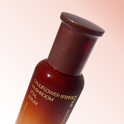 Amber bottle of serum featuring cauliflower mushroom extract with moisture boost benefits on soft gradient background