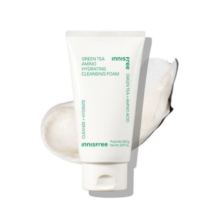 White tube of hydrating cleansing foam with green text positioned on creamy foam swatch in soft light background