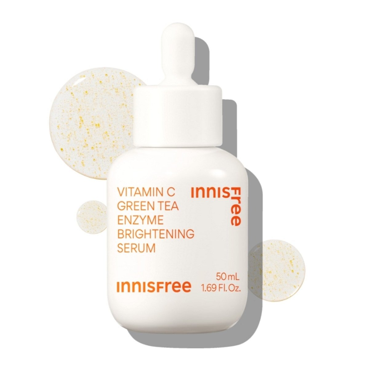 White dropper bottle of brightening serum with orange text and translucent vitamin C droplets on white background